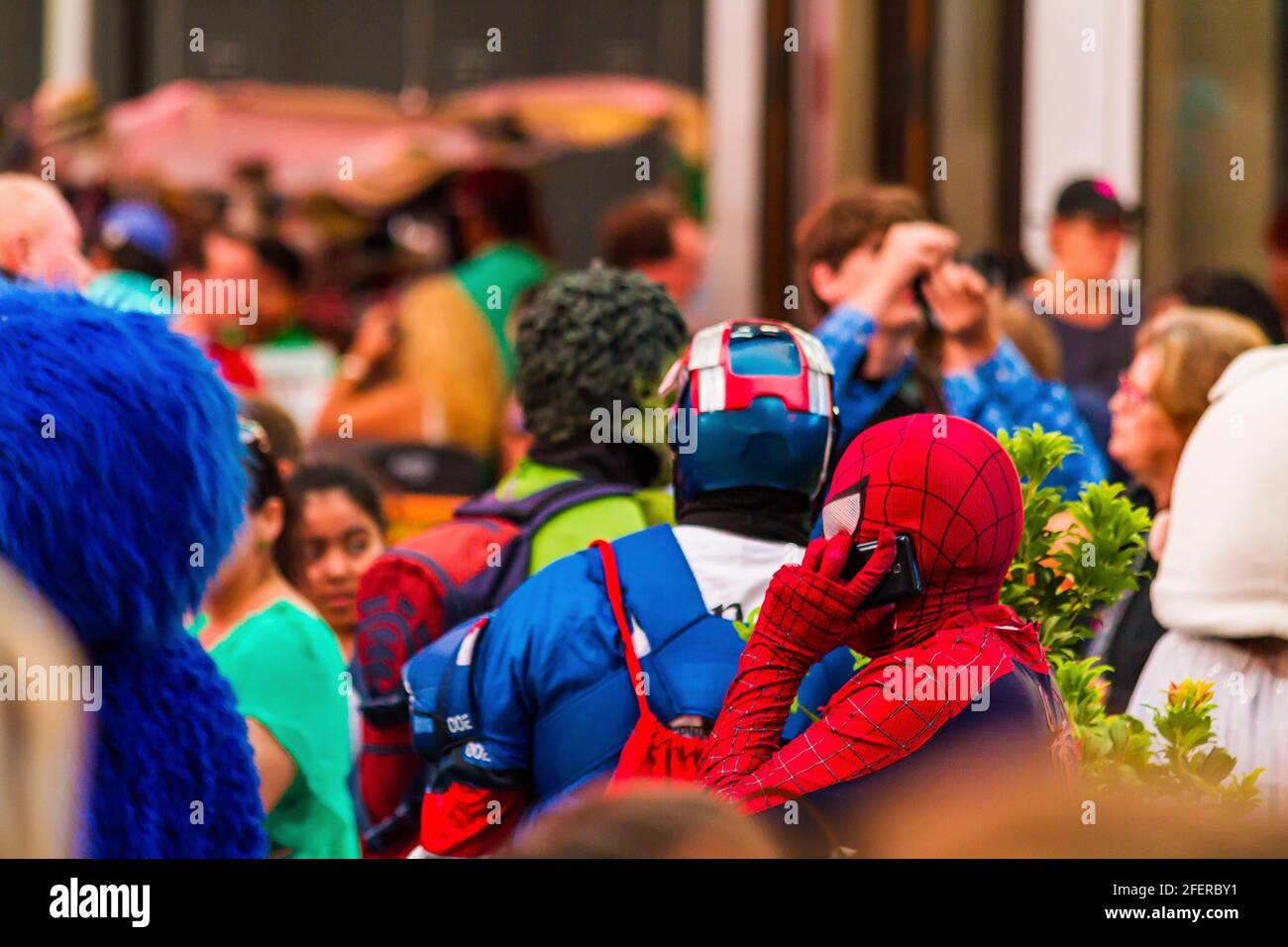 Primo piano di un uomo in un costume Spiderman che parla Al telefono a Times Square e alle persone in sfondo Foto Stock