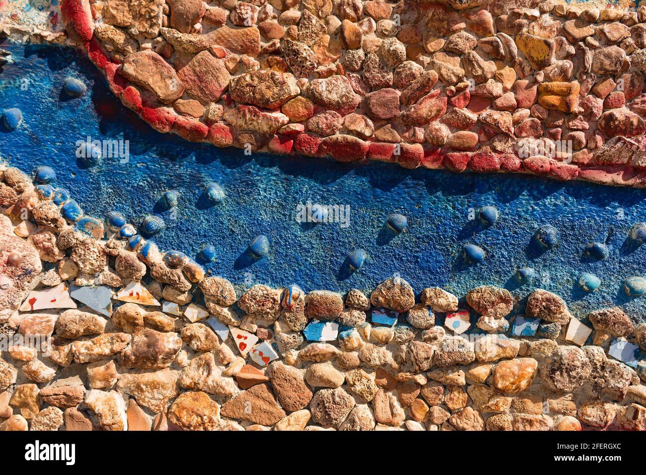 Primo piano vista della decorazione delle pareti realizzata con piccole pietre e conchiglie di mare nei colori blu e rosso. Riflessione sulla cultura e la vita del Mar Egeo e del Mediterraneo Foto Stock