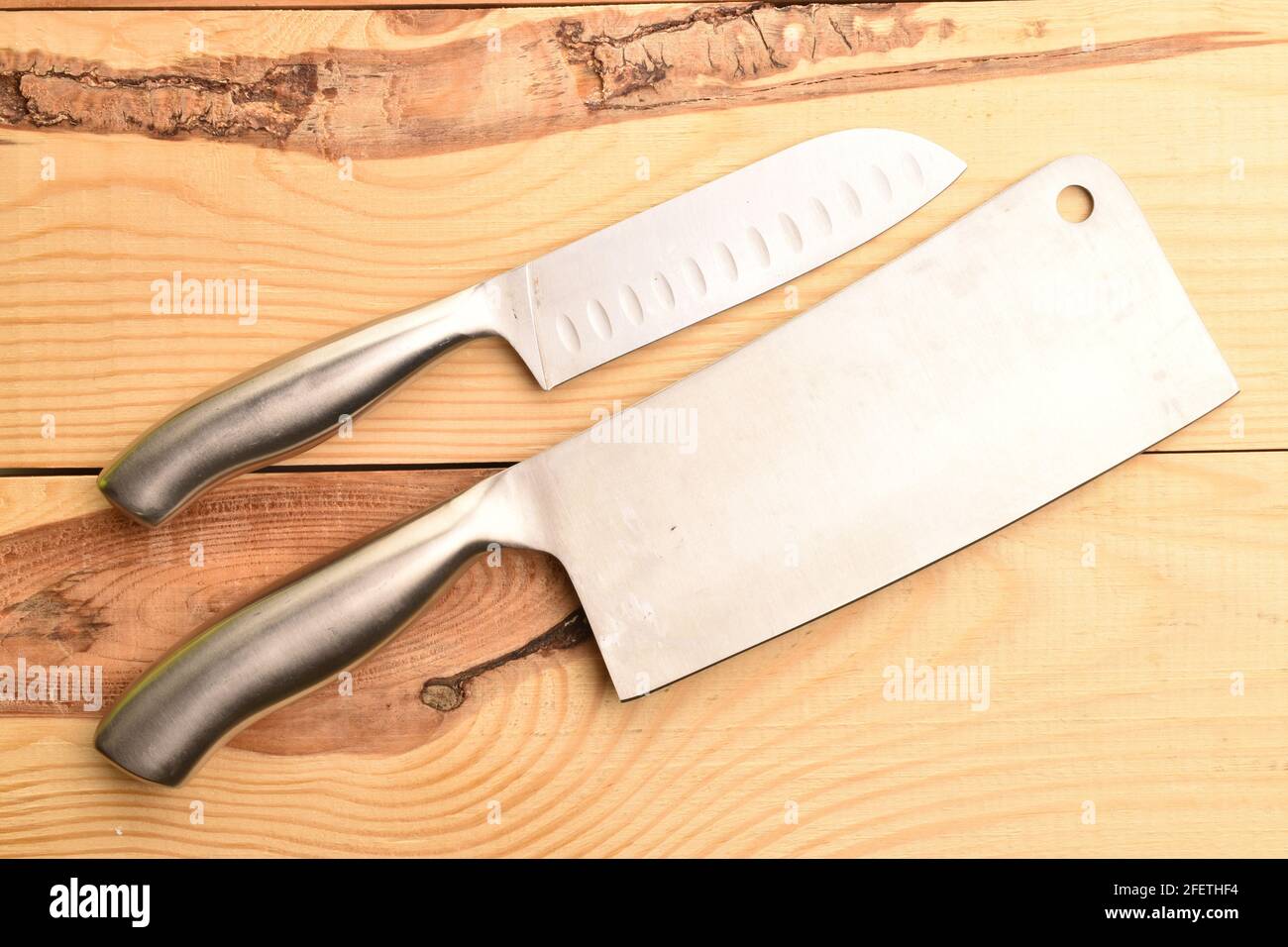 Due coltelli metallici, primo piano, su un tavolo di legno. Foto Stock