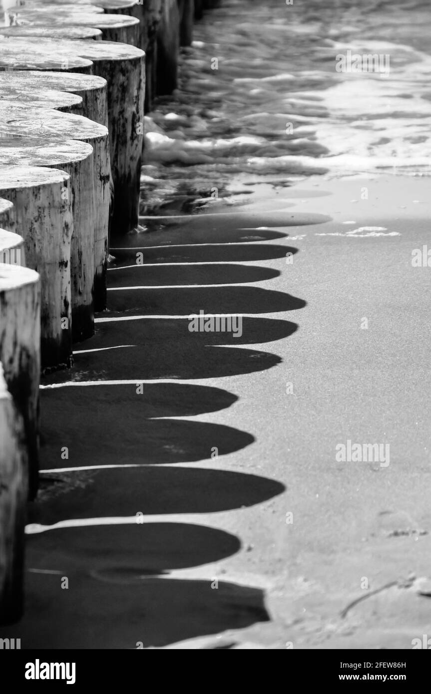 Vista sul Mar Baltico con surf leggero. In primo piano una fila di frangiflutti Foto Stock