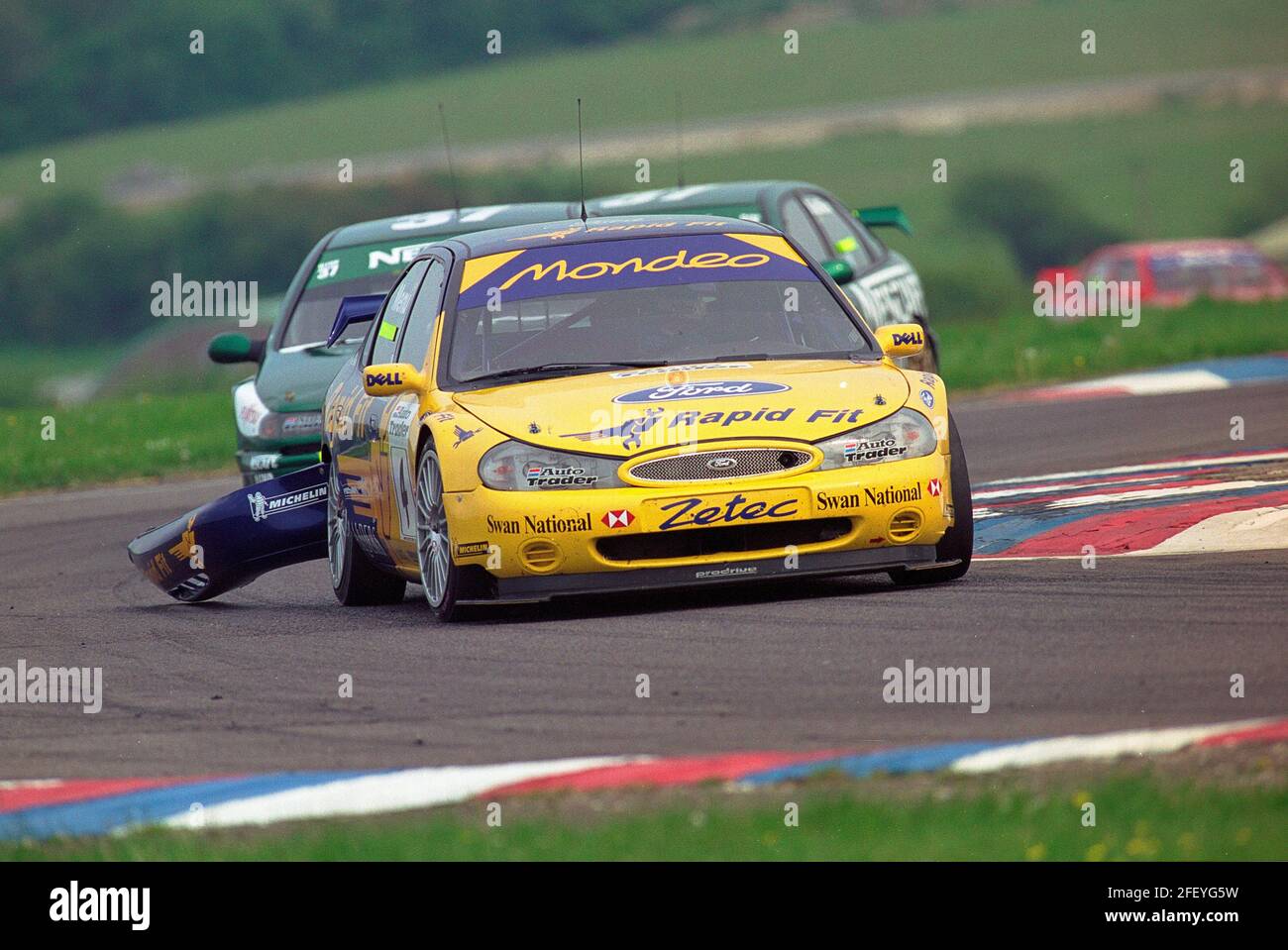 Alain Menu con il paraurti posteriore appeso al suo Ford Team Mondeo che viene cacciato giù da Jason Plato e Jean-Christophe Boullion nel loro Nescafe Blend 37 Williams Renault Laguna durante il campionato 1999 British Touring Car a Thruxton England. Foto Stock