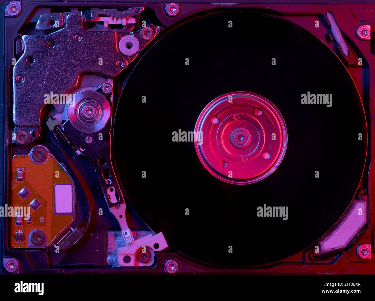 Vista ravvicinata del disco rigido di un computer con illuminazione rosso-blu. Foto Stock