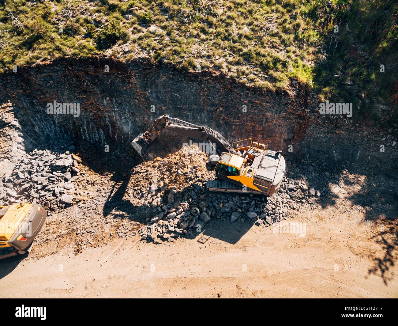 Il trattore cingolato giallo sta lavorando all'estrazione della roccia. Vista dall'alto Foto Stock