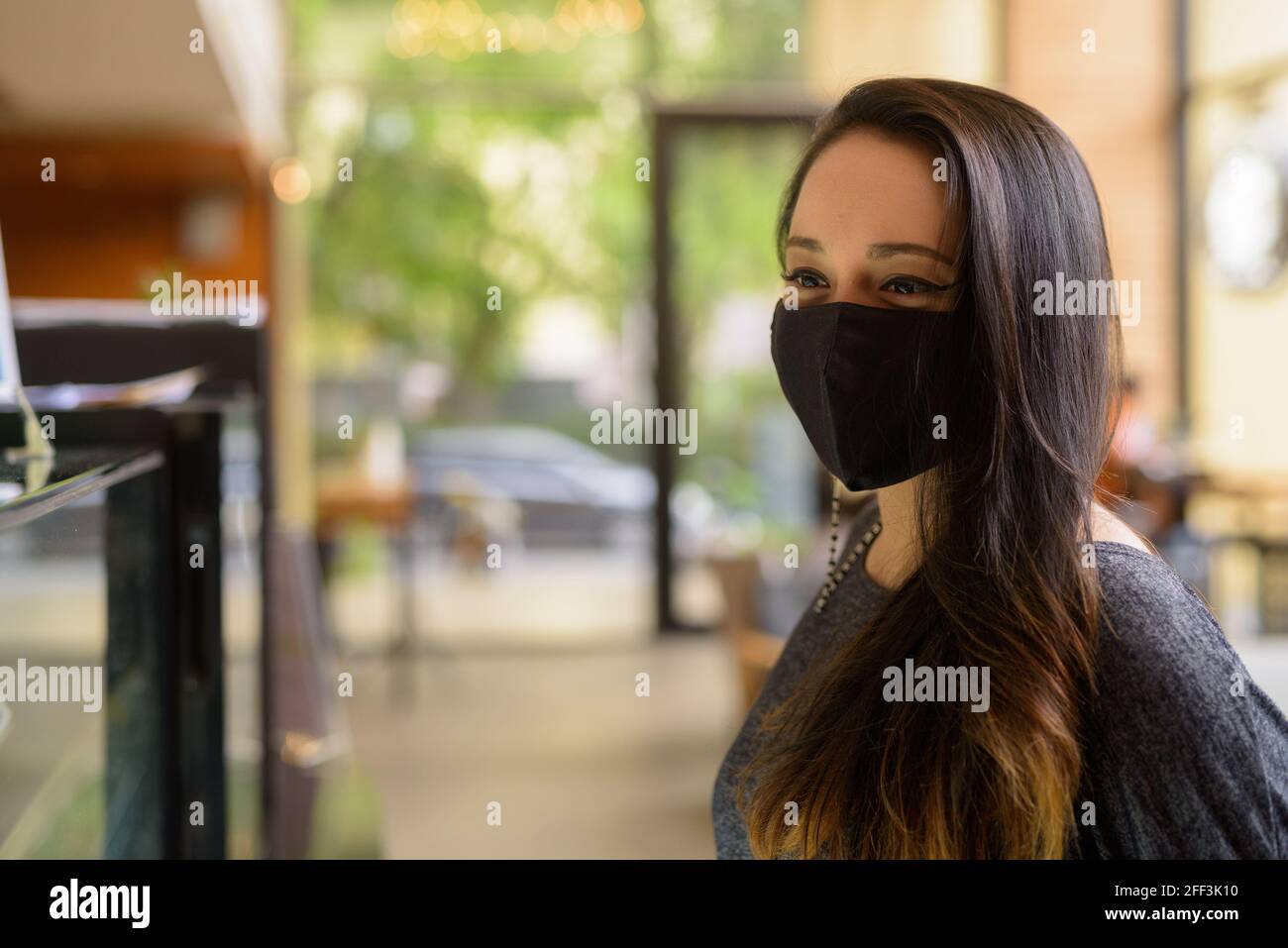 Ritratto di donna che indossa maschera per la protezione contro il coronavirus Covid-19 al ristorante Foto Stock