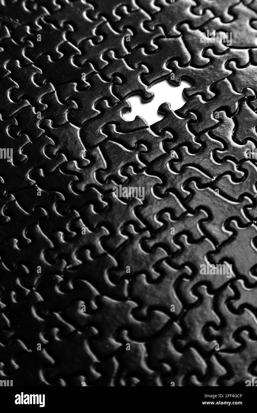 Puzzle nero pezzi sfondo con pezzo mancante Foto Stock