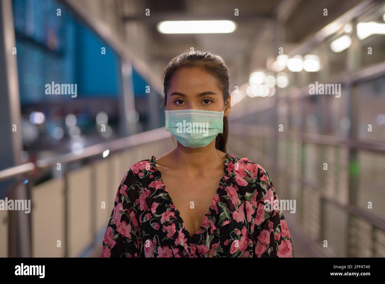 Ritratto di donna che indossa maschera per la protezione contro il coronavirus Covid-19 di notte Foto Stock