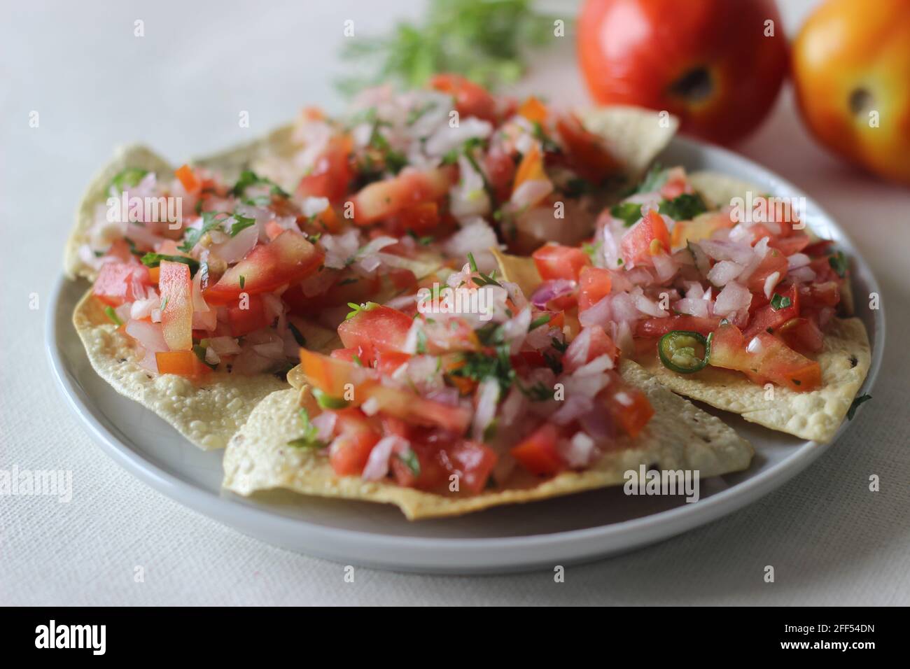 Papadi croccanti e fritti con un masala ripieno di cipolle, pomodori e spezie. Antipasto popolare dall'India del Nord comunemente conosciuto come papad del masala. S Foto Stock