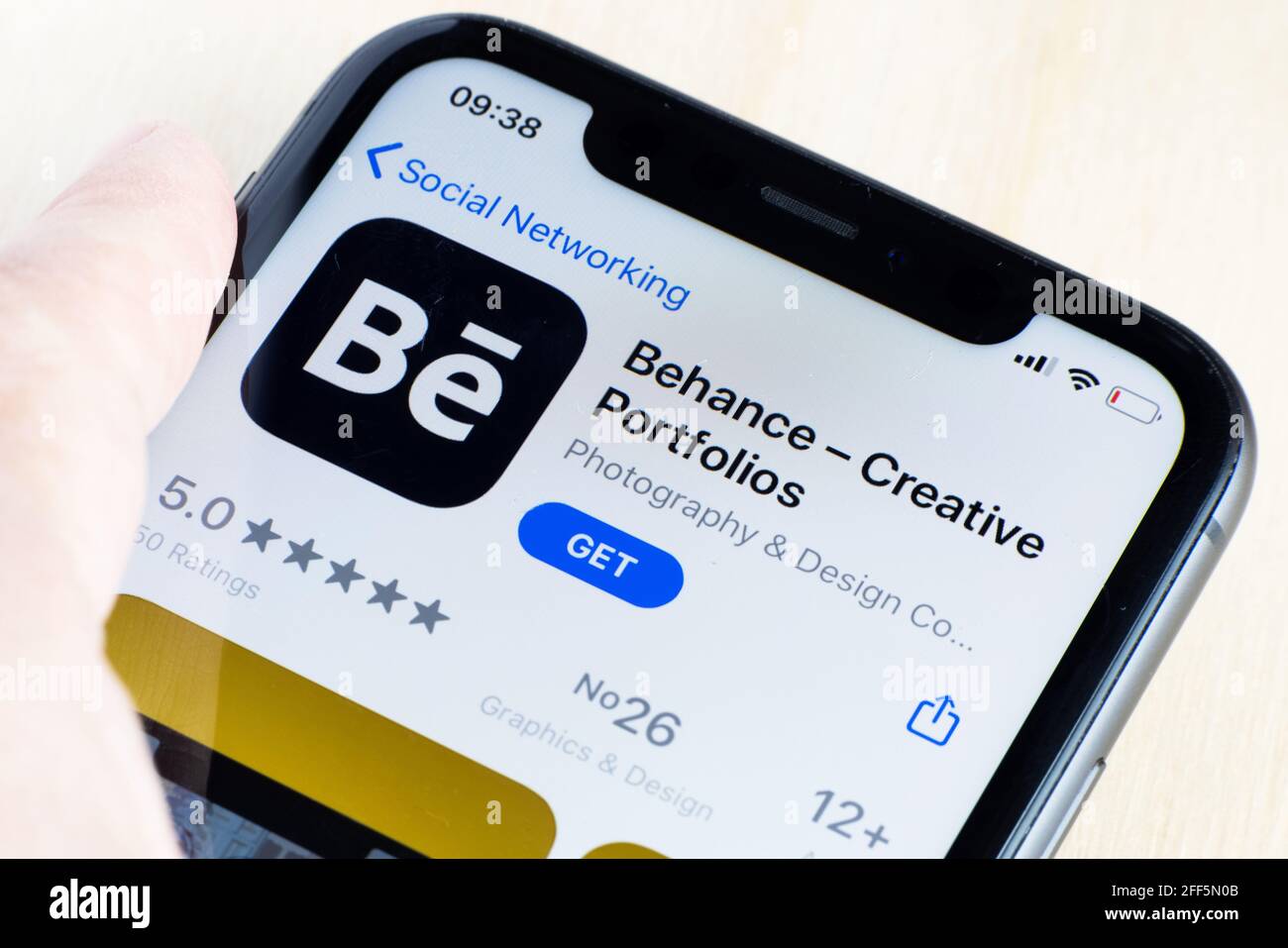 Donna che scarica l'app Behance su AppStore. Behance è una piattaforma di social media di proprietà di Adobe "per mostrare e scoprire il lavoro creativo". Foto Stock