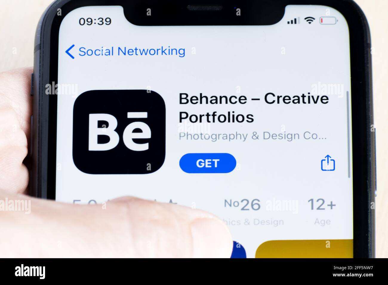 Donna che scarica l'app Behance su AppStore. Behance è una piattaforma di social media di proprietà di Adobe "per mostrare e scoprire il lavoro creativo" Foto Stock