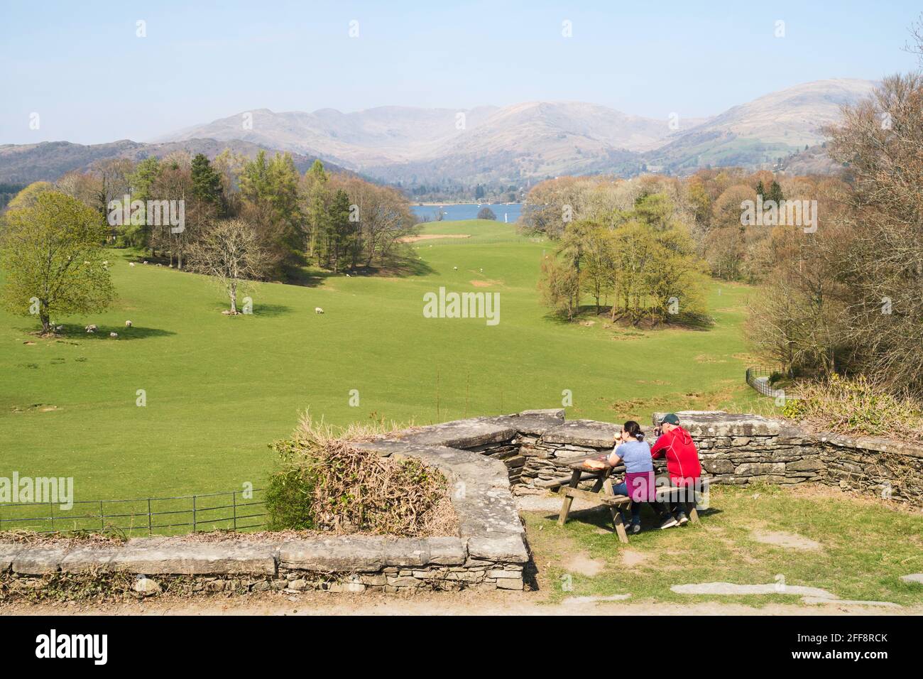 Coppia seduta sulla terrazza del Castello di Wray con lago Windermere sullo sfondo, Low Wray, Cumbria, Inghilterra, Regno Unito Foto Stock