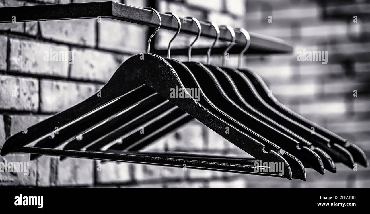 Diversi tipi di appendiabiti alla moda. Appendiabiti in legno. Molti hangers neri di legno su un'asta. Bianco e nero Foto Stock