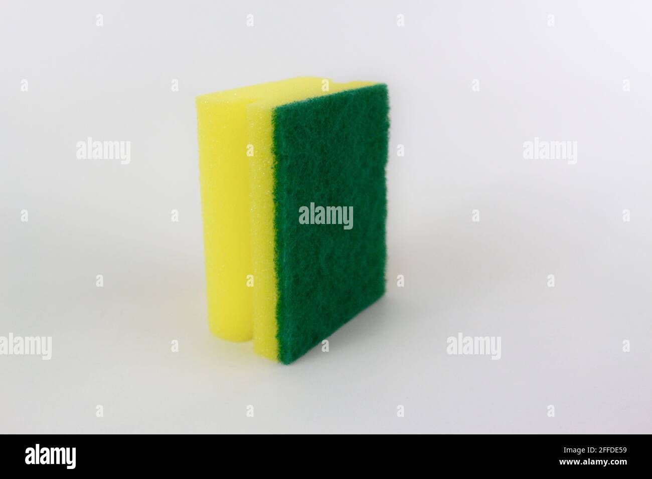 Spugna verde gialla sul lato isolata su sfondo bianco Foto Stock