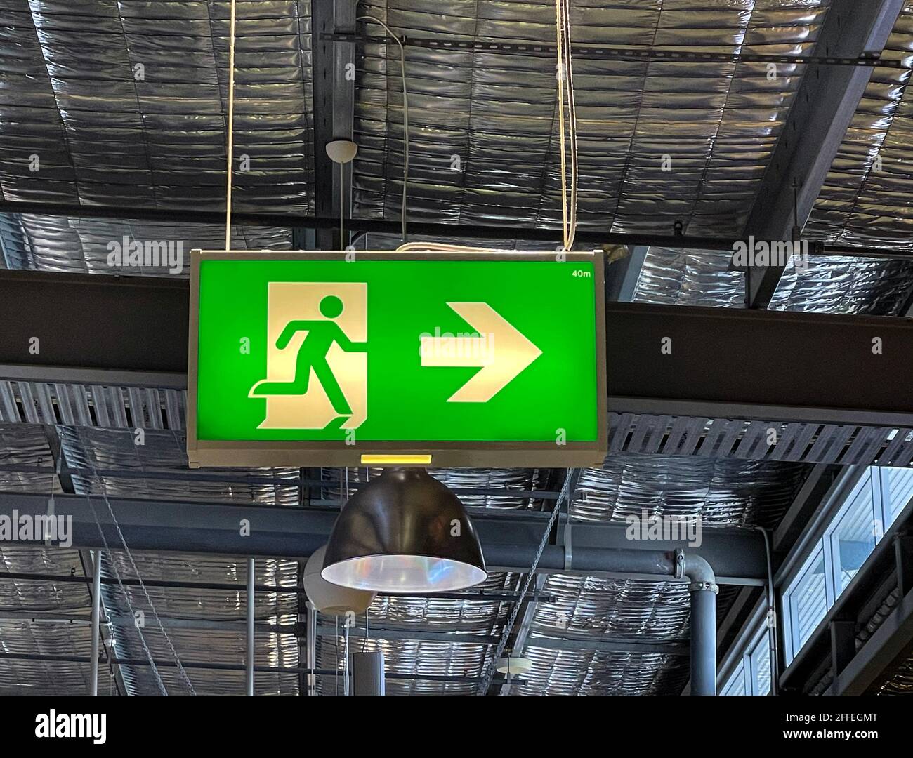 Negozio classico Fire Exit e Emergency Escape nel area pubblica di un centro commerciale raffigurante una corsa uomo e una freccia che indica le direzioni Foto Stock