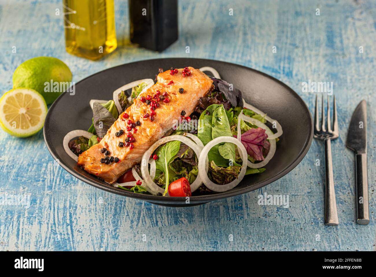 insalata di salmone verde e sana in piatto nero Foto Stock