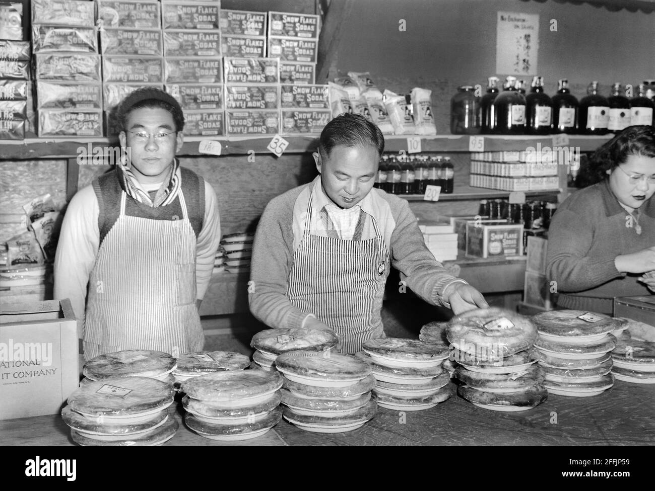 Lavoratori in piedi dietro banco presso il negozio Co-op, Manzanar Relocation Center, California, USA, Ansel Adams, Manzanar War Relocation Center Collection, 1943 Foto Stock