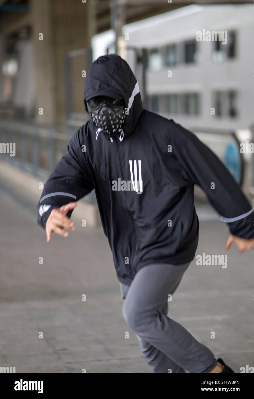Maschera nera con borchie su uomo vestito con felpa con cappuccio