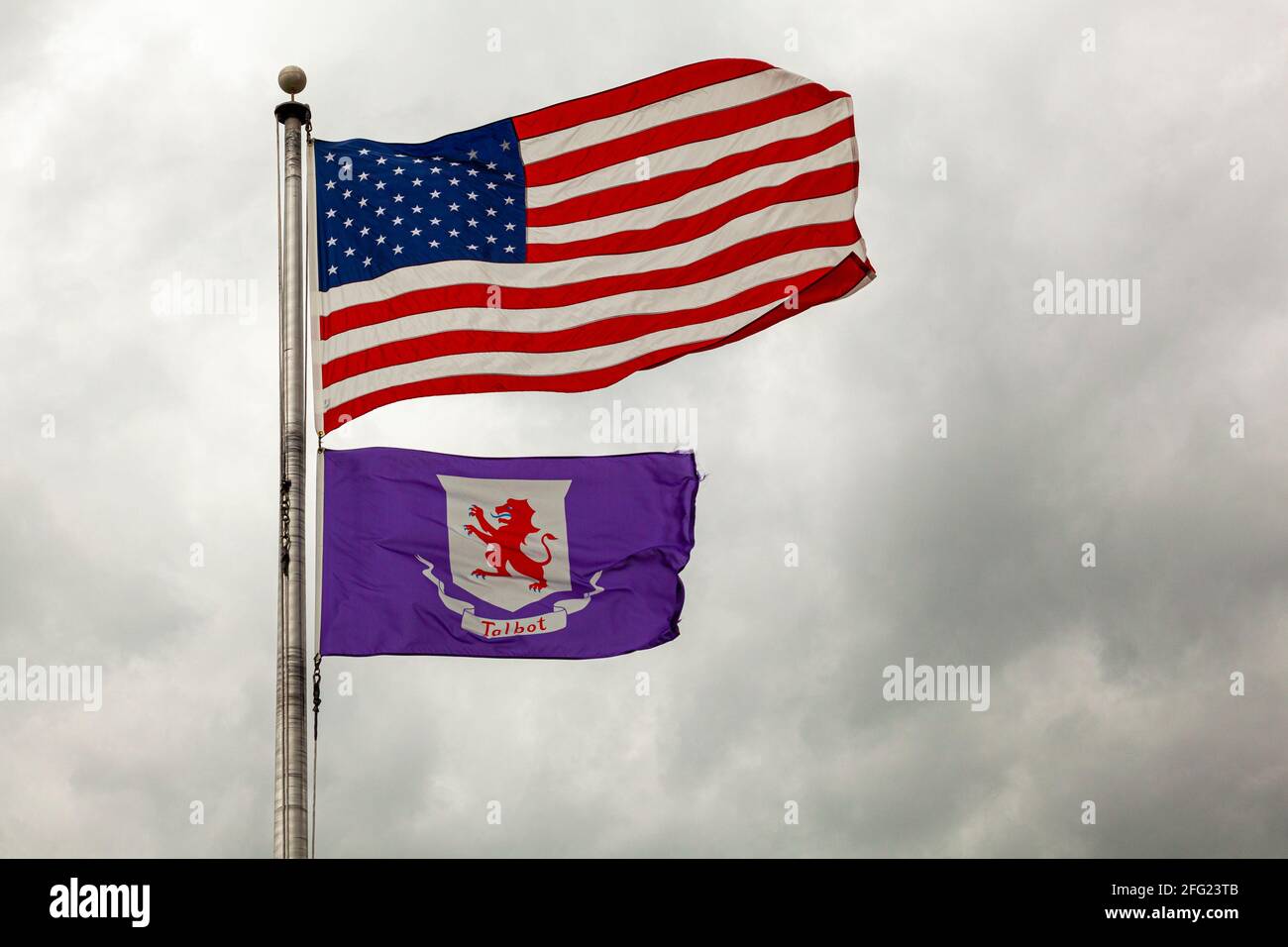 Bandiere degli Stati Uniti d'America e della contea di Talbot, Maryland stanno volando insieme su un posto di bandiera contro cielo nuvoloso. Immagine isolata con spin copia Foto Stock