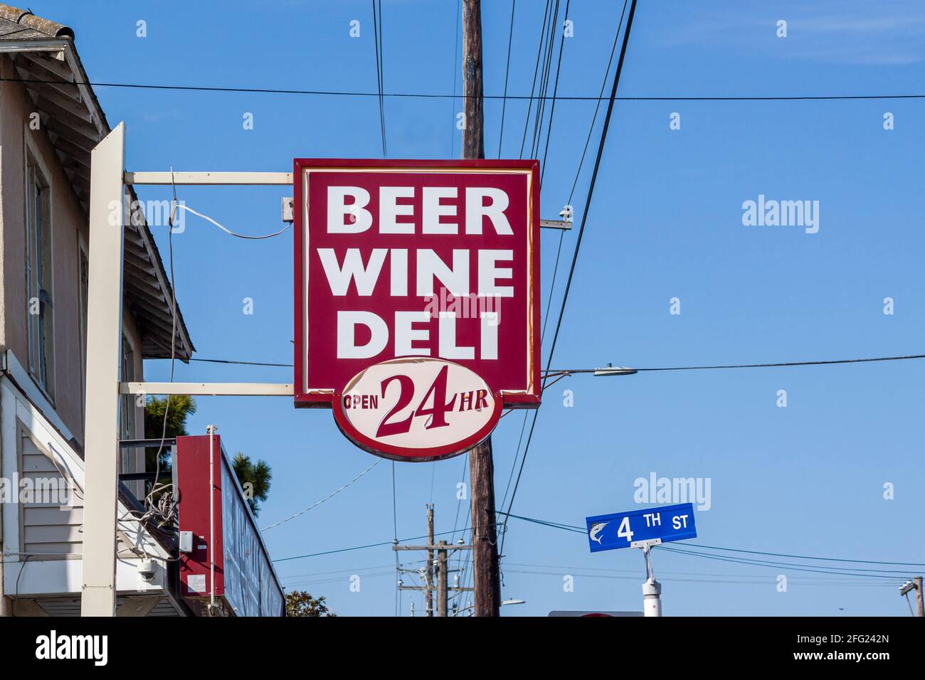 Un cartello generico di fronte ad un minimarket in una città turistica. E' aperto 24 ore su 24 per birra, vino e gastronomia. Questi piccoli negozi sono popolari a. Foto Stock