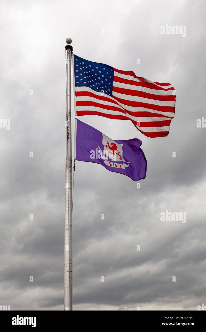 Bandiere degli Stati Uniti d'America e della contea di Talbot, Maryland stanno volando insieme su un posto di bandiera contro cielo nuvoloso. Immagine isolata con spin copia Foto Stock