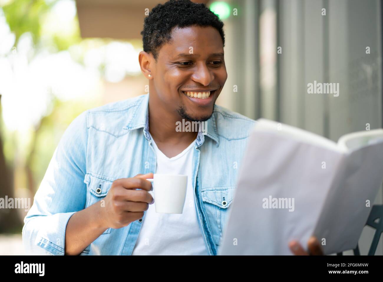 Uomo che legge un libro alla caffetteria. Foto Stock
