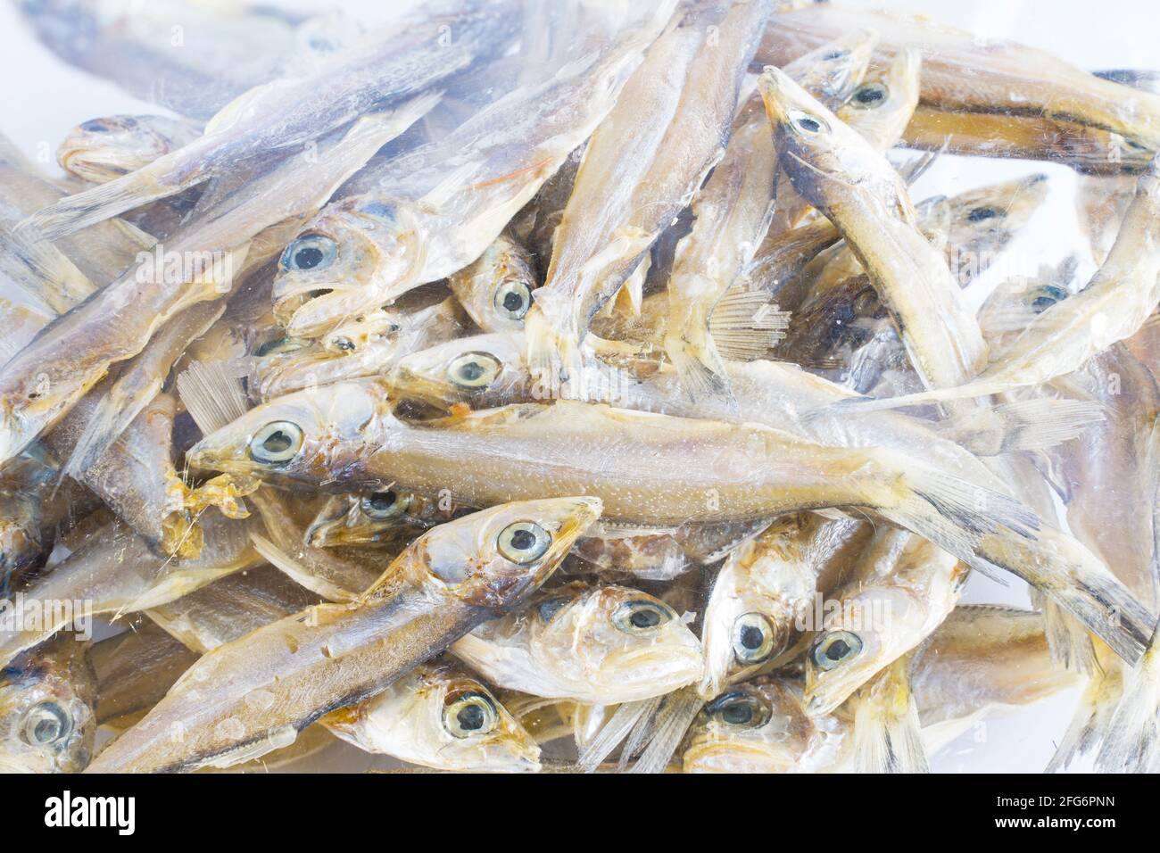 Pesce piccolo essiccato, sono raccolti in sacchetti di plastica da vendere su un mercato, cucina di calcio Foto Stock