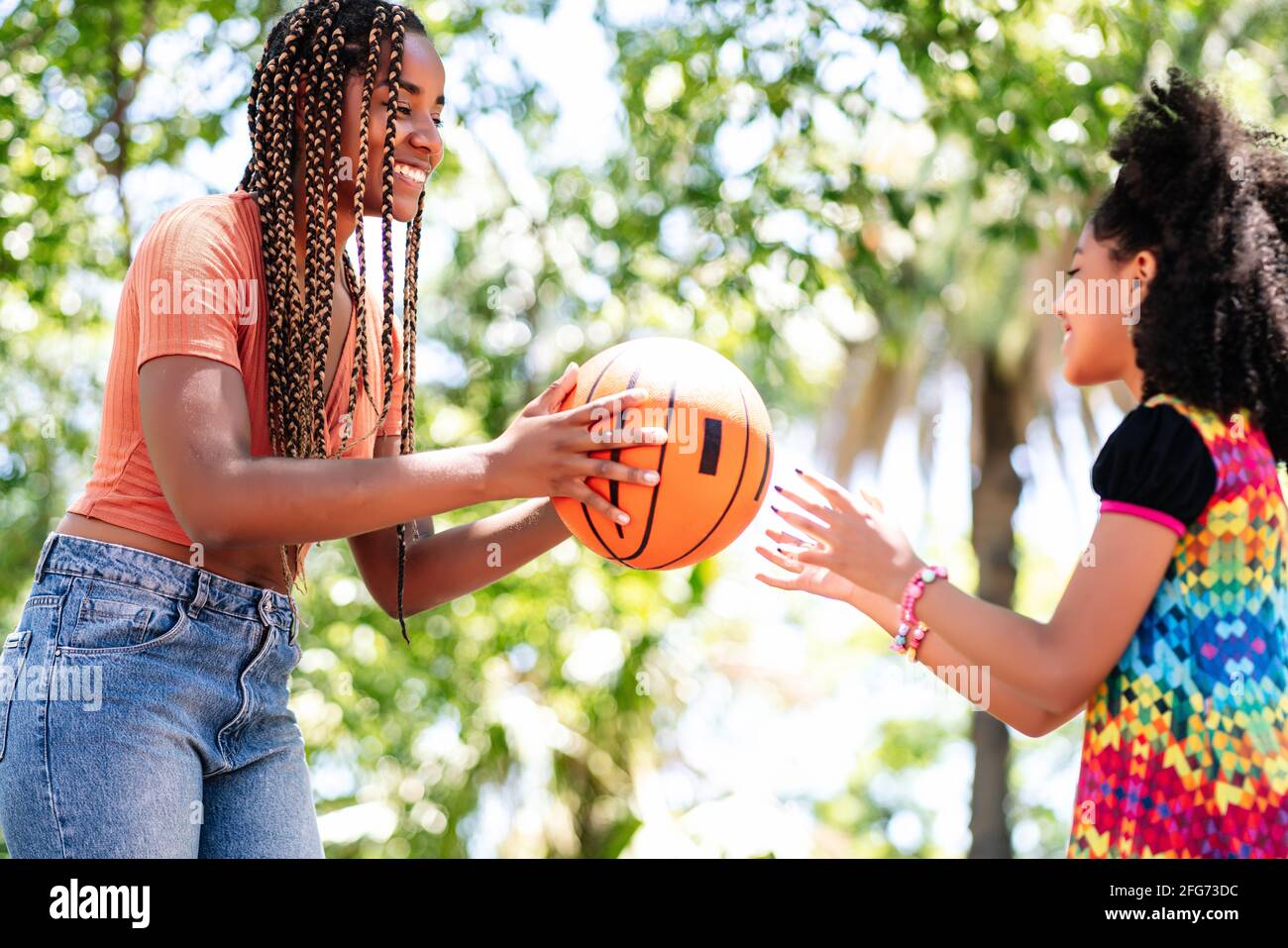 Madre e figlia giocano a basket al parco. Foto Stock