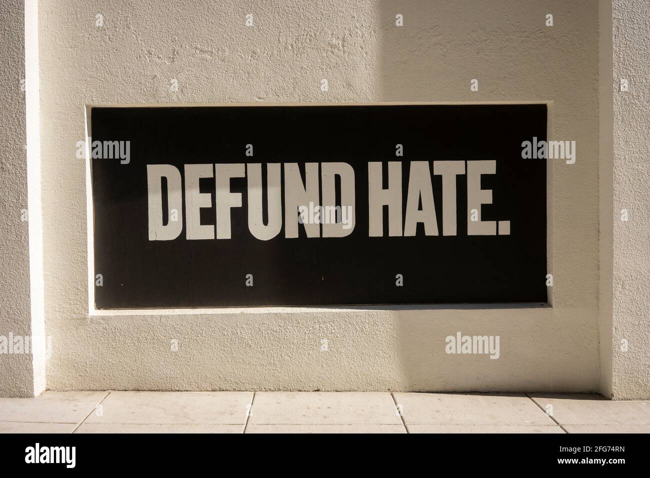 Defund odio. Slogan positivo dipinto sulla finestra di imbarco durante le proteste. Foto Stock