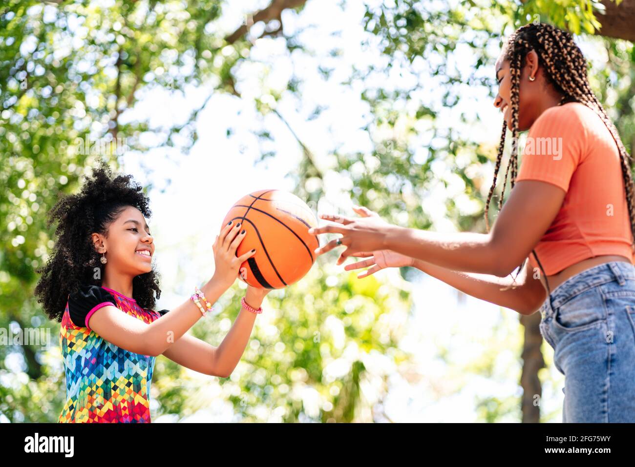 Madre e figlia giocano a basket al parco. Foto Stock