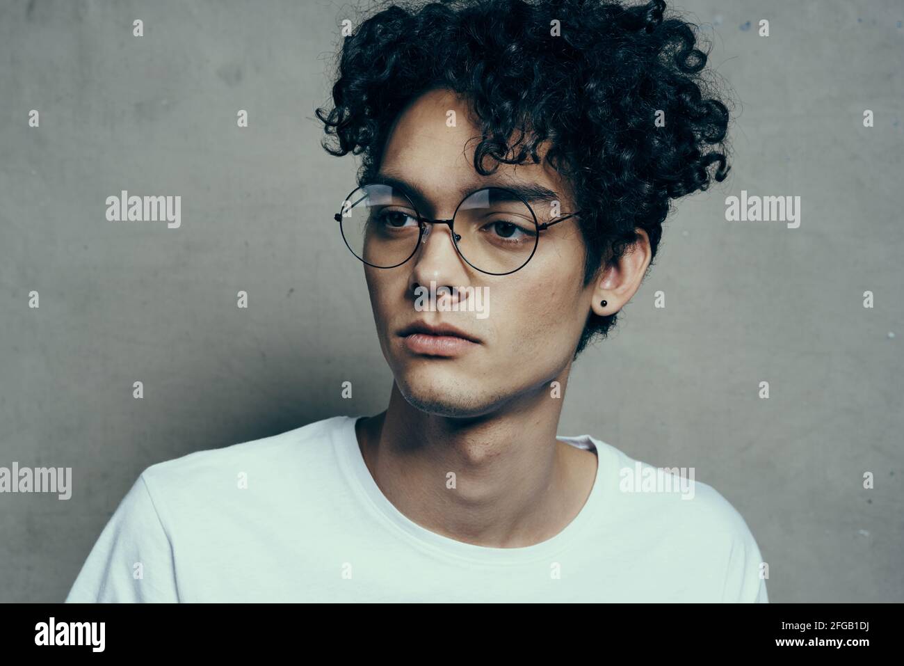 uomo con capelli ricci corti look occhiali studio di moda Foto stock - Alamy