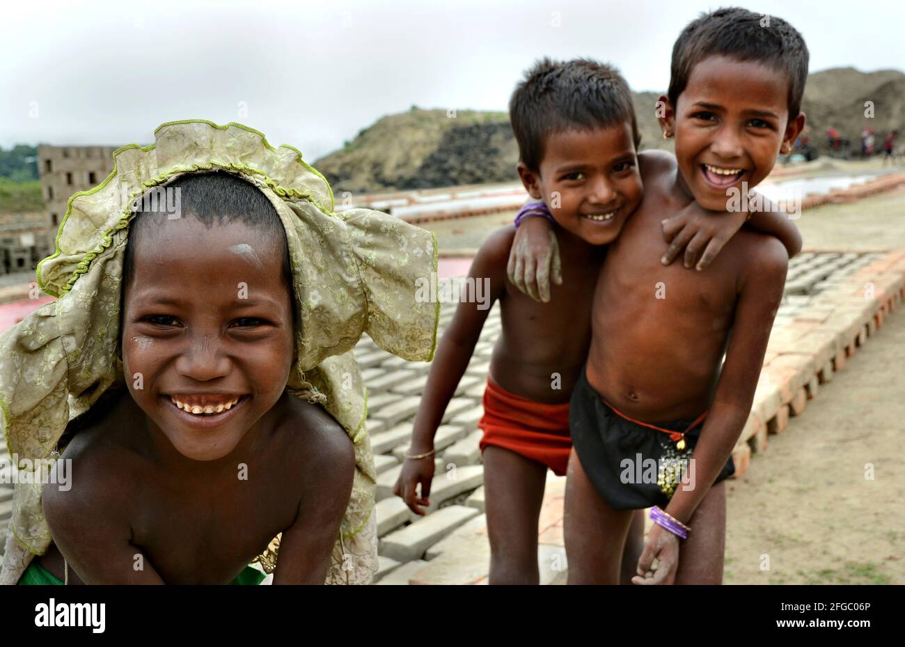 I bambini del campo di mattoni stanno giocando e godono la loro vita piccola nel villaggio remoto del Bengala Occidentale in India. Foto Stock