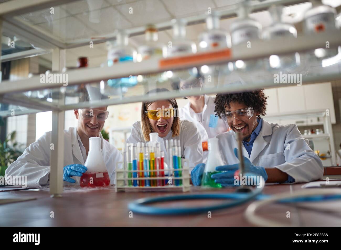 Giovani studenti di chimica in un ambiente di laboratorio sterile amano lavorare con prodotti chimici colorati. Scienza, chimica, laboratorio, persone Foto Stock