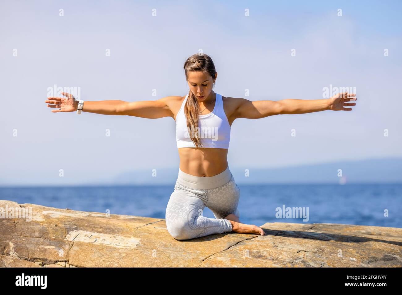 Fit Donna esercizio Yoga stretching con le braccia allungate Foto Stock