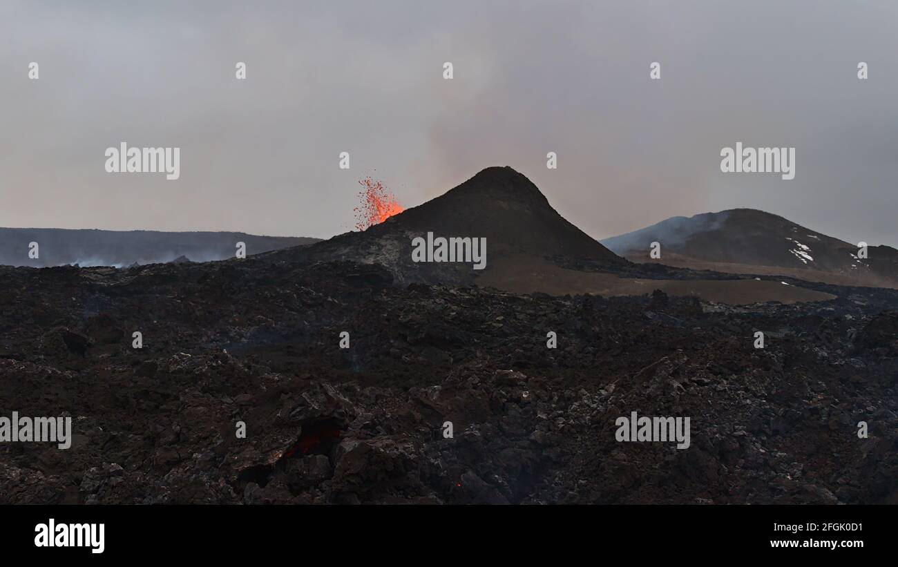 Vista mozzafiato del vulcano in eruzione che espelle lava calda nella valle di Geldingadalir vicino al monte Fagradalsfjall, Grindavík, penisola di Reykjanes, Islanda. Foto Stock