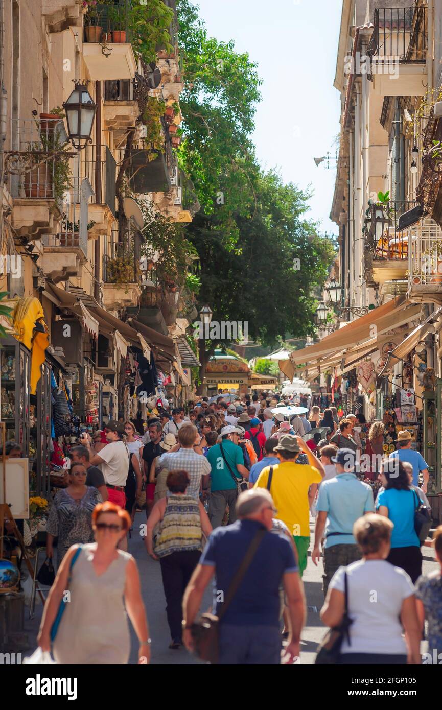 Italia strada, vista in estate di turisti in una strada trafficata nel centro storico di Taormina, Sicilia, Italia, Europa. Foto Stock