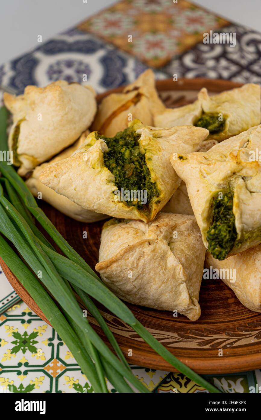Torte con aglio selvatico e cipolle verdi. Cibo fatto in casa. Pasta sfoglia. Cottura su un piatto, primo piano. Cibo locale. Ramson Foto Stock