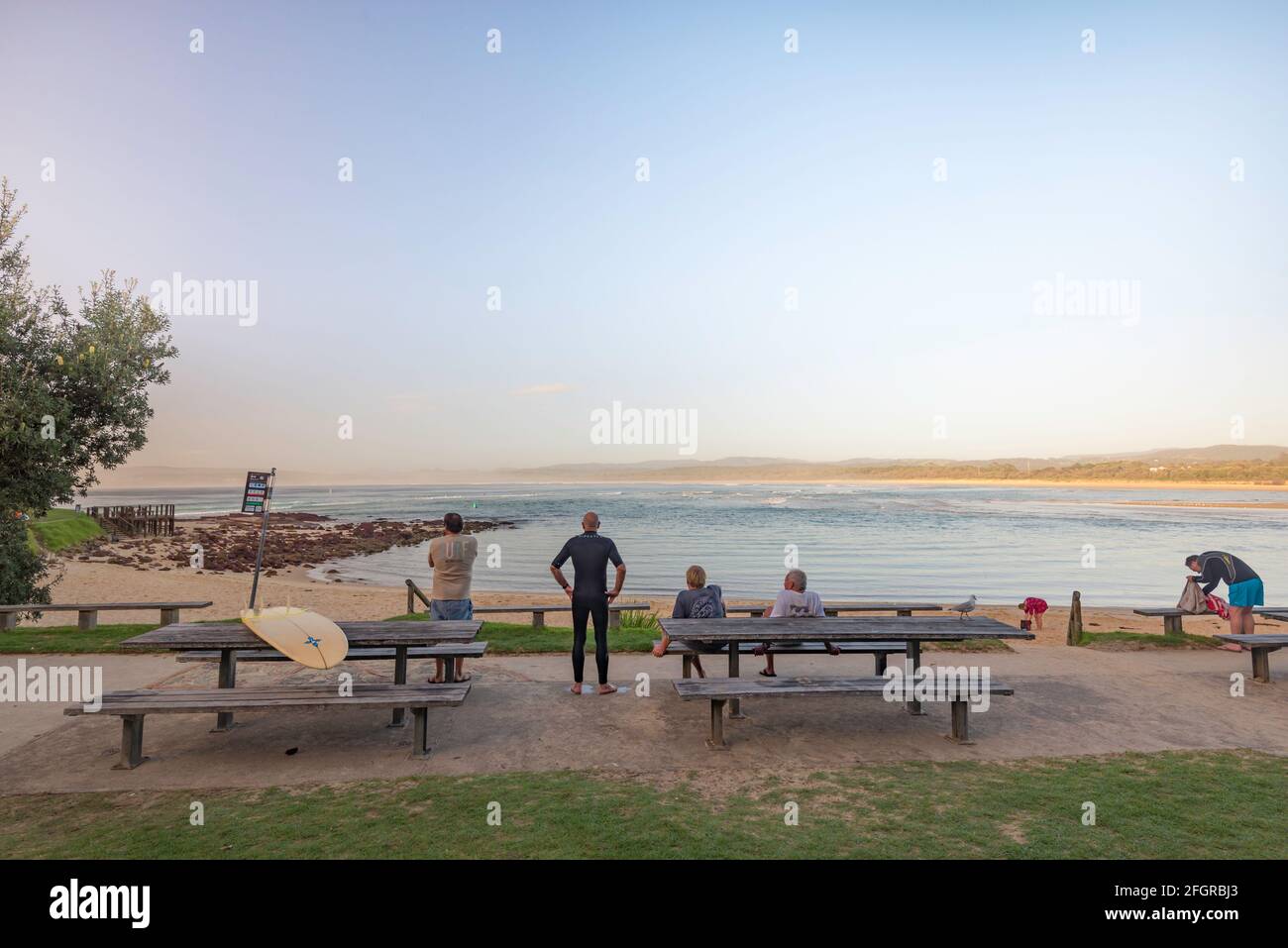 Boardriders giovani e vecchi guardano il surf al Bar Beach A Merimbula sulla costa sud del nuovo Galles del Sud Australia al mattino presto Foto Stock