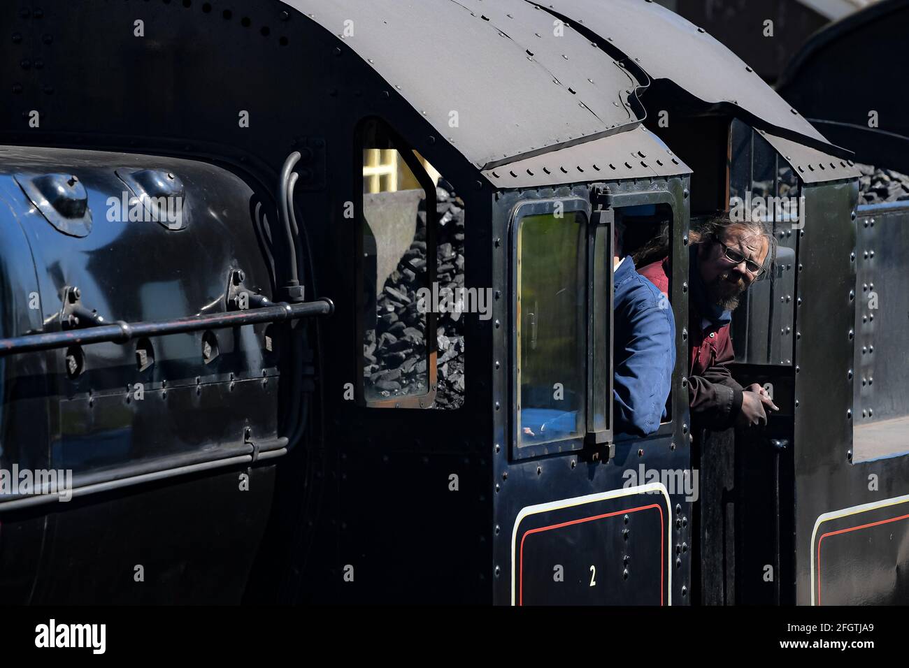 Un autista di un treno a vapore si affaccia dal piatto della stazione di Cranmore, Somerset, sulla East Somerset Railway, durante il primo fine settimana di gala a vapore come meccanismo di blocco. Data immagine: Domenica 25 aprile 2021. Foto Stock Un autista di un treno a vapore si affaccia dal piatto della stazione di Cranmore, Somerset, sulla East Somerset Railway, durante il primo fine settimana di gala a vapore come meccanismo di blocco. Data immagine: Domenica 25 aprile 2021. Foto Stock