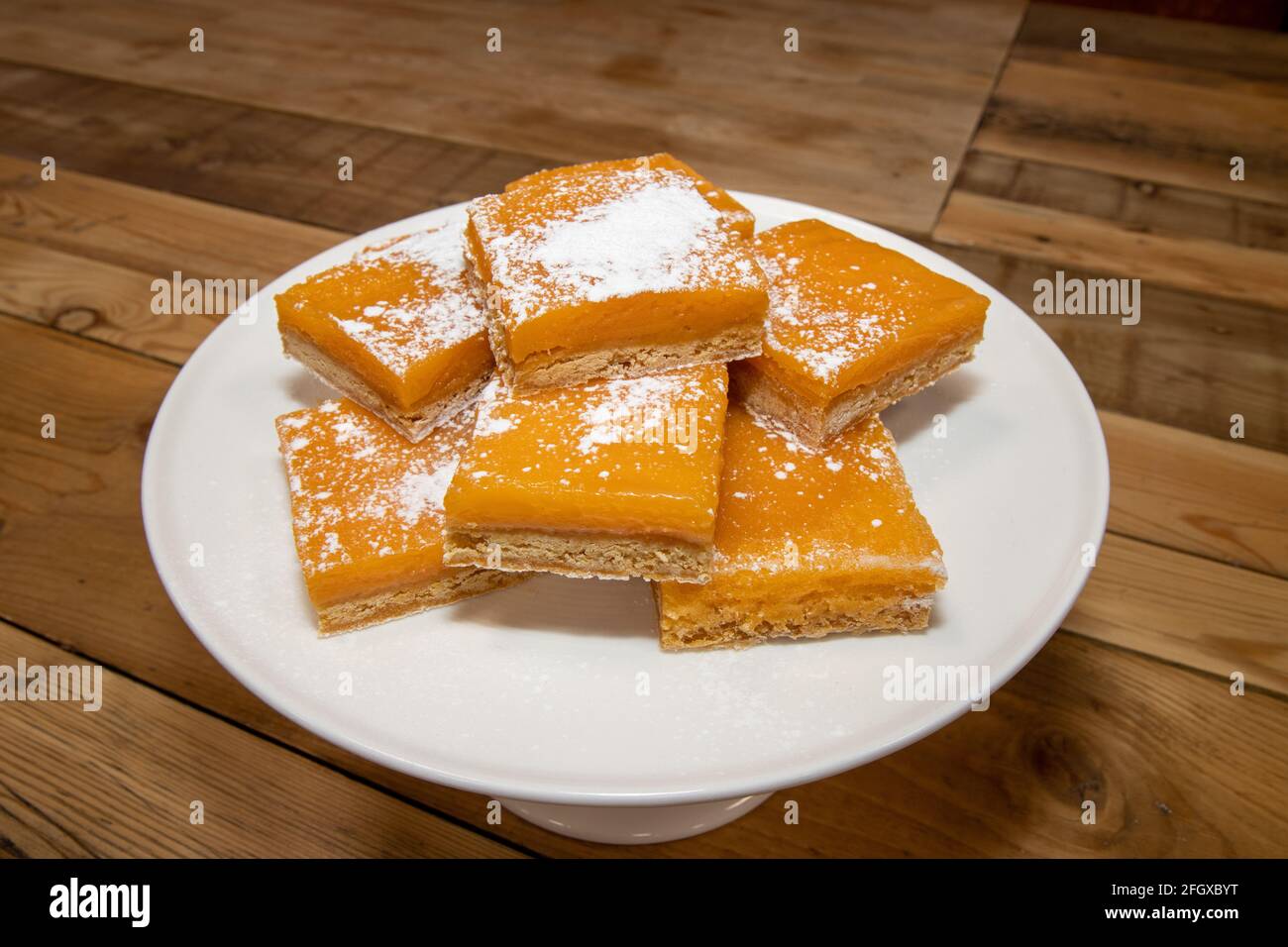 Un mucchio di deliziose piazze di limone, dolci fatti in casa su un tavolo da cucina in legno Foto Stock