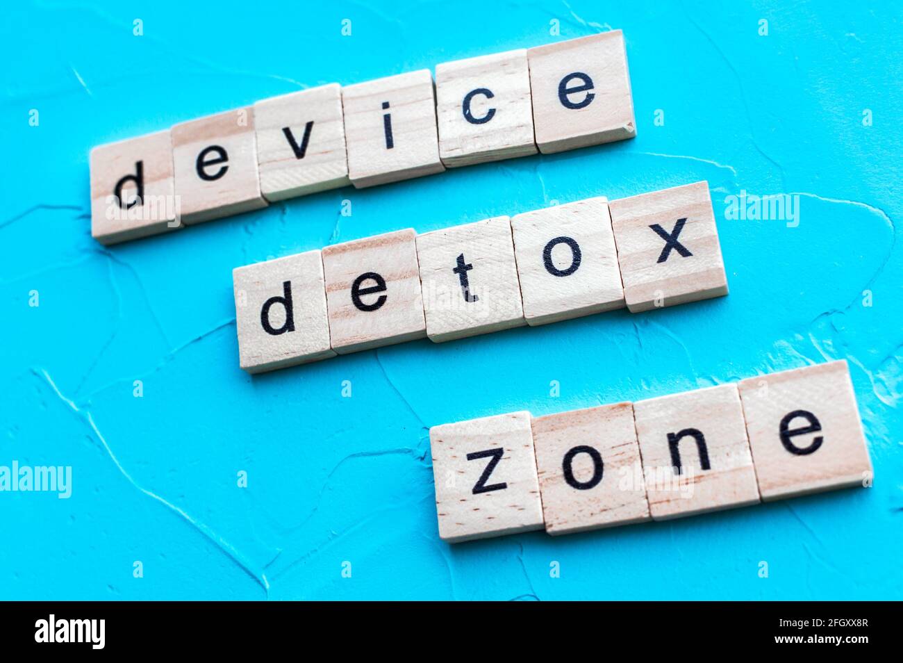 Concept detox digitale. Dispositivo di iscrizione detox zona su sfondo blu Foto Stock