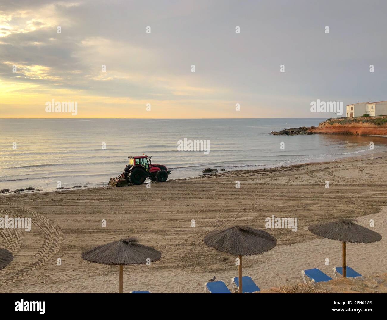 Alicante, Spagna - Alicante, 2021: Trattore di pulizia spiaggia di mare da piante di alghe all'alba di mattina presto Foto Stock