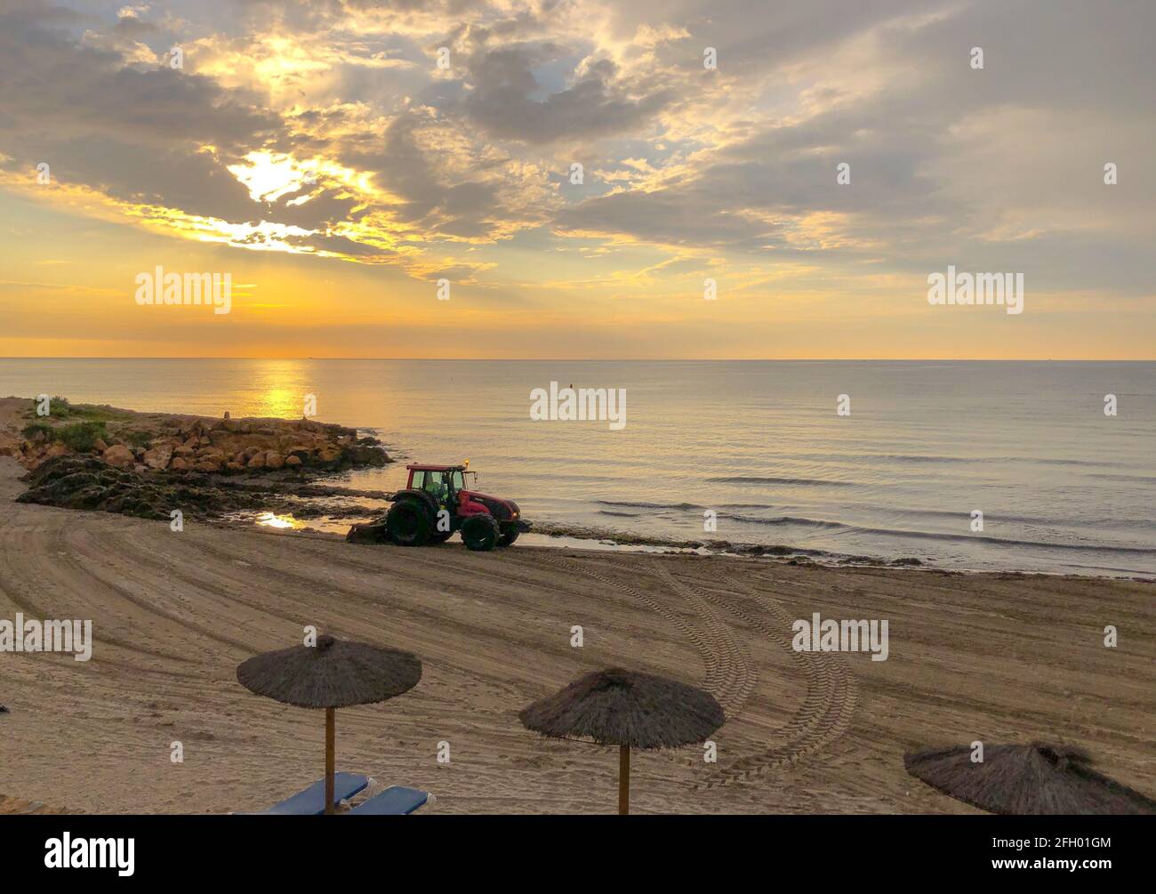 Alicante, Spagna - Alicante, 2021: Trattore di pulizia spiaggia di mare da piante di alghe all'alba di mattina presto Foto Stock