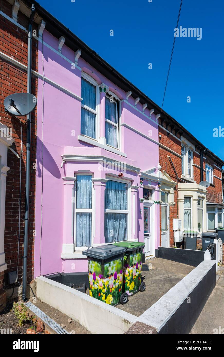 Piccola casa a schiera rosa colorato in parte di una terrazza di case in una strada residenziale a Emsworth, Hampshire, Inghilterra, Regno Unito. Foto Stock