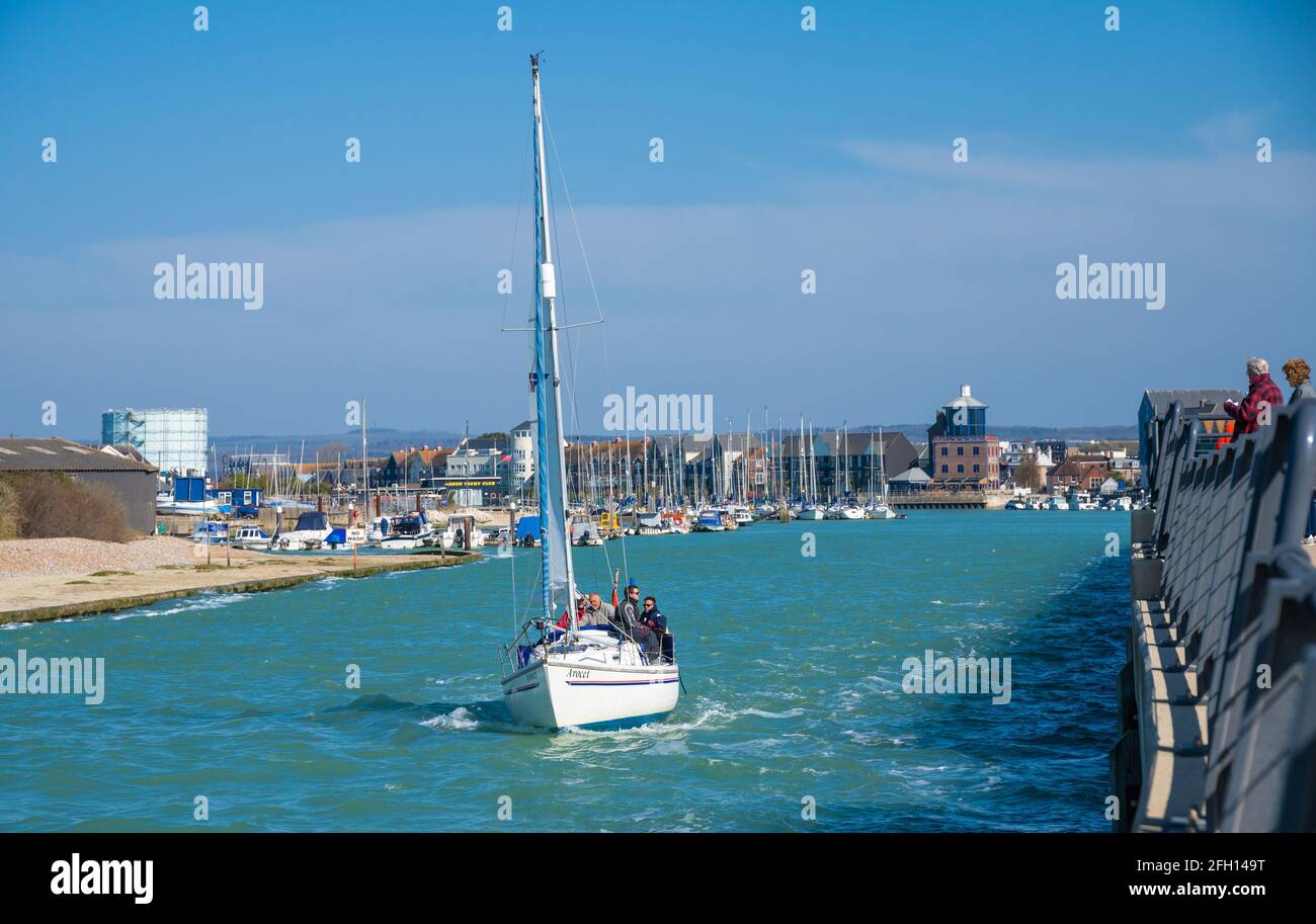Gruppo di persone in viaggio in barca a vela su un piccolo yacht, che viaggia fino all'estuario del fiume Arun in primavera a Littlehampton, West Sussex, Inghilterra, Regno Unito. Foto Stock