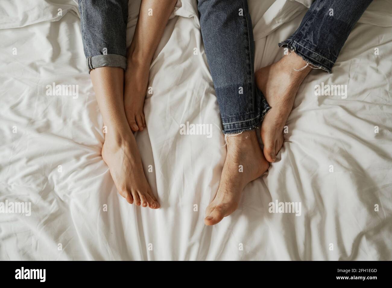 Primo piano gambe di giovane coppia in jeans cattivo indossare Foto Stock