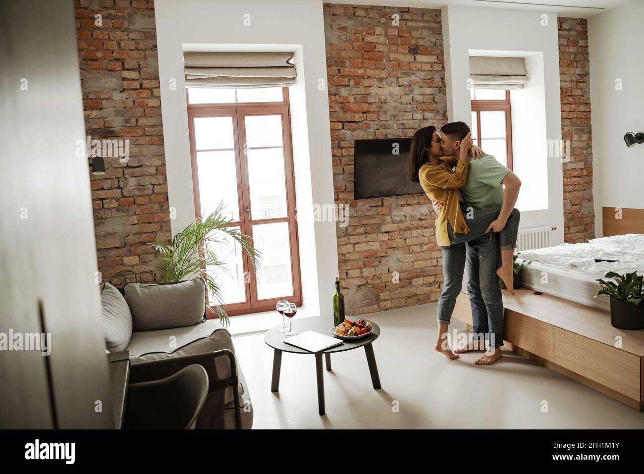 Felice giovane coppia sta ballando e mostrando i loro sentimenti in nuovo appartamento. Bella famiglia che si sposta in nuovo appartamento Foto Stock