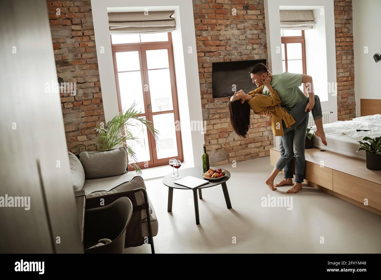 Felice giovane coppia sta ballando e mostrando i loro sentimenti in nuovo appartamento. Bella famiglia che si sposta in nuovo appartamento Foto Stock