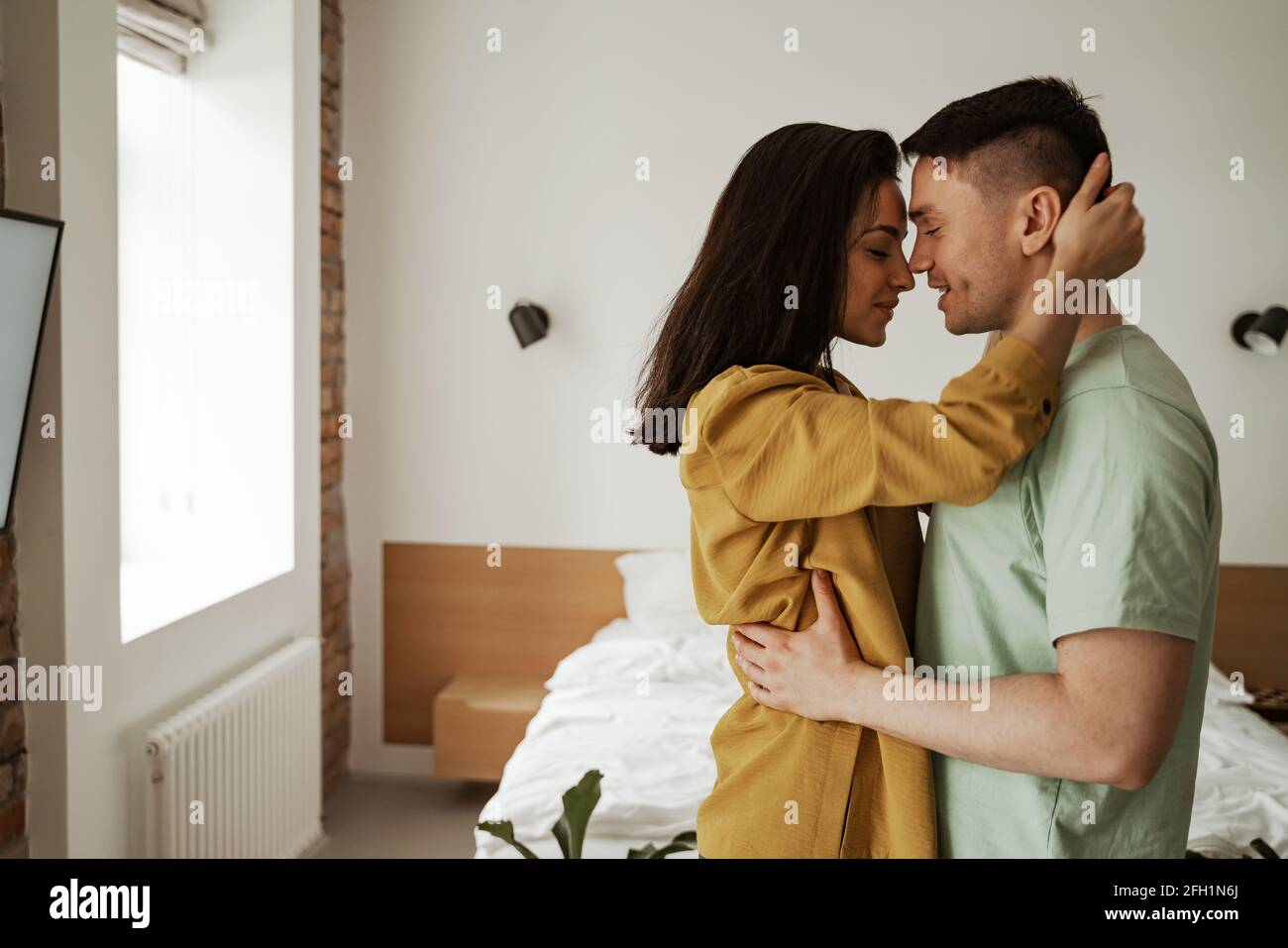 Felice giovane coppia è abbracciando e mostrando i loro sentimenti. Giovane famiglia che si sposta in un nuovo appartamento Foto Stock