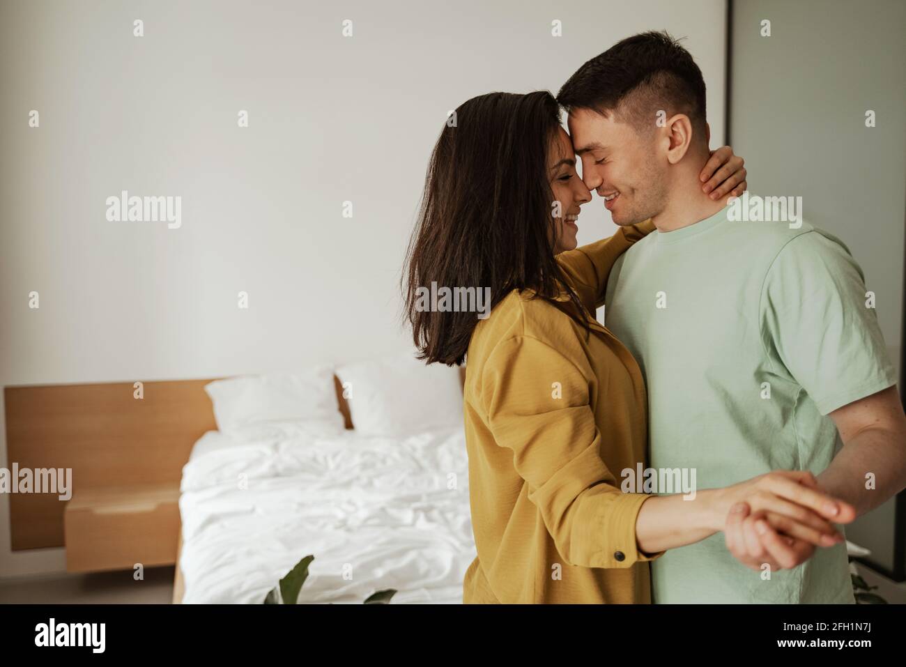 Felice giovane coppia è abbracciando e mostrando i loro sentimenti. Bella famiglia che si sposta in nuovo appartamento Foto Stock