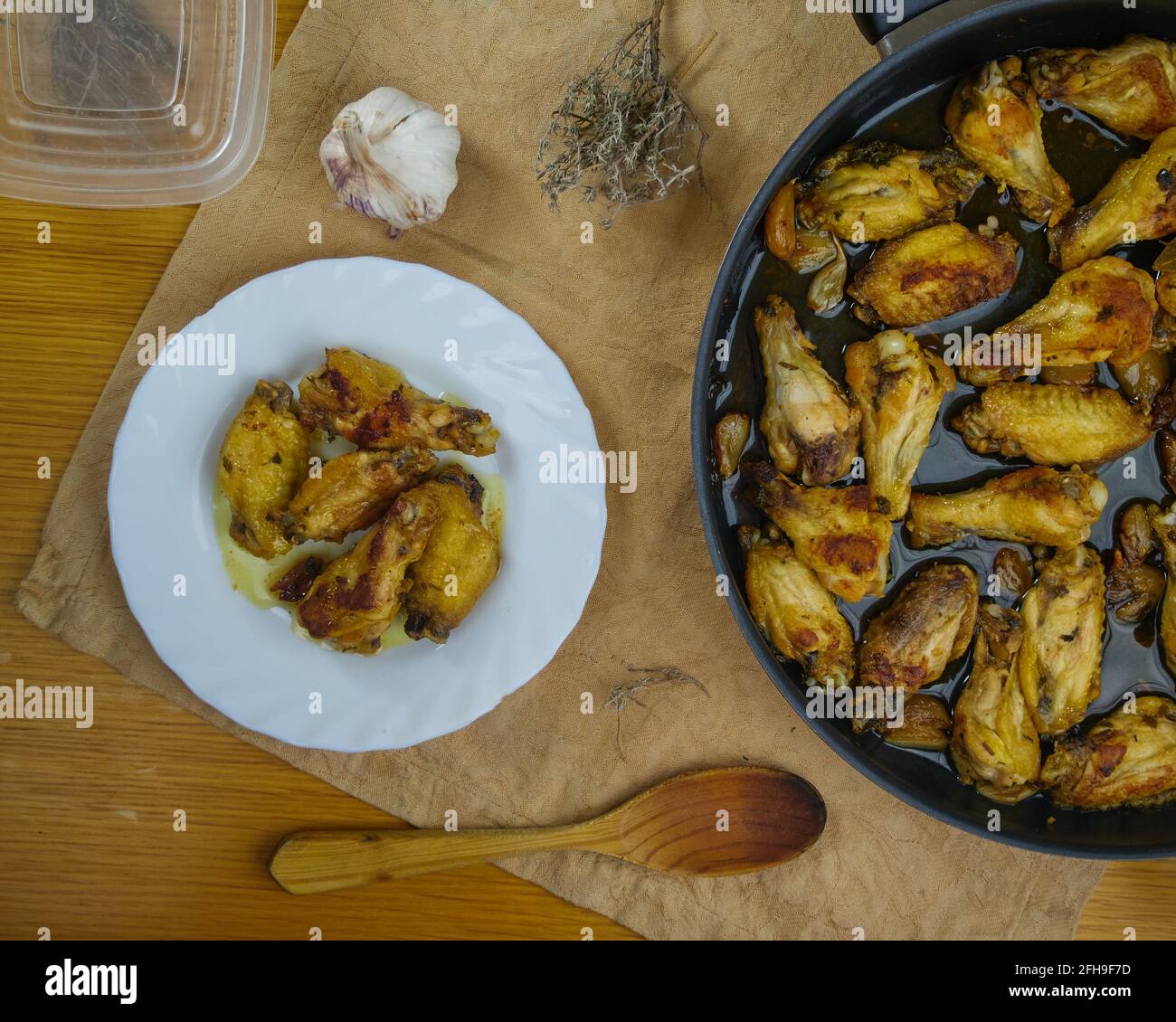 Ali di pollo all'aglio (Pollo al ajillo). Piatto spagnolo di Tapa in un piatto decorato con una paellera e i suoi ingredienti. Vista dall'alto Foto Stock
