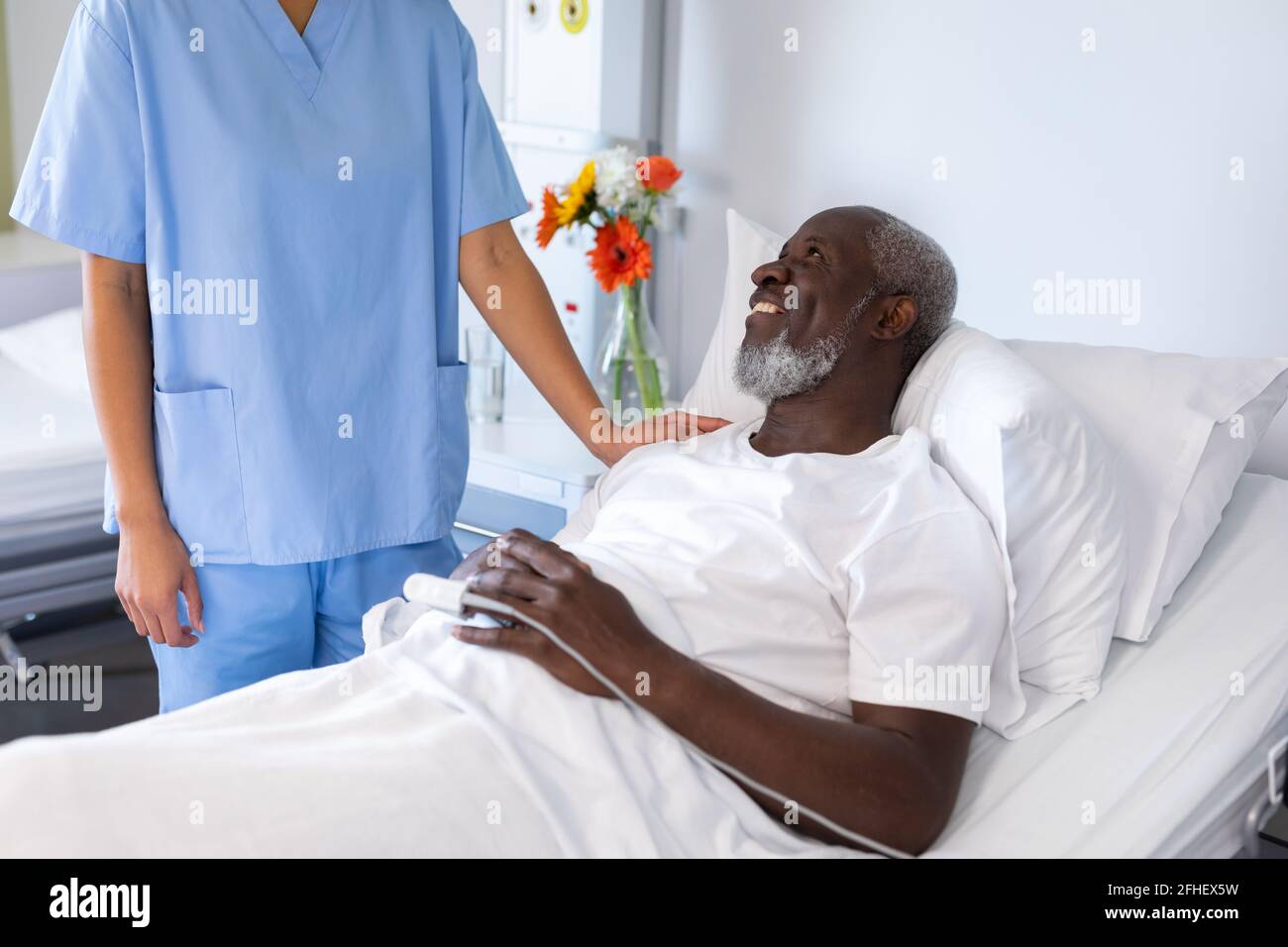 African american maschio sorridente a misto razza femmina dottore in sala paziente dell'ospedale Foto Stock